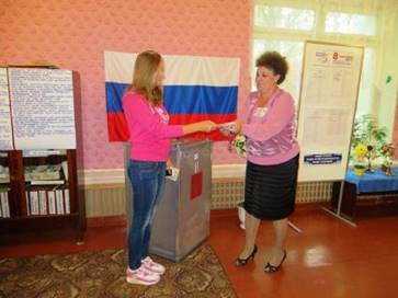ПредседательЕ.В. Маценко поздравляет впервые голосующих.